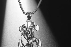 Macro view of eagle and anchor pendant showing intricate vintage punk metal textures