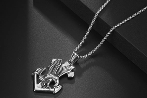 Detailed macro view of silver eagle and anchor pendant with intricate feather textures