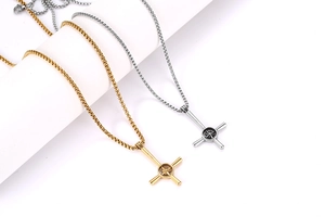 Dettaglio dei pendenti a croce e stella in acciaio inossidabile oro e argento su catene