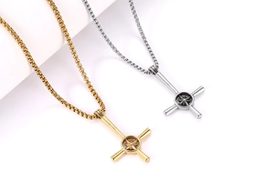 Dettaglio di pendenti a croce oro e argento con motivi a stella su catene box