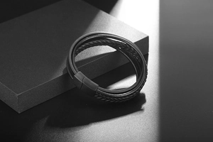 Detail of multi-layer woven black leather bracelet with matte black magnetic metal clasp