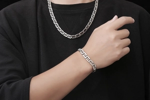 Polished silver geometric chain necklace and bracelet set shown on male model
