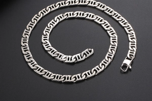 Macro detail of silver geometric rectangle chain link necklace with polished steel finish