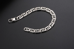 Macro shot of silver pig nose chain links with lobster clasp on a black textured background