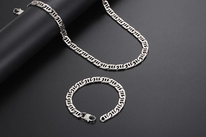 Detail of silver titanium steel necklace and bracelet set with geometric hollow link design