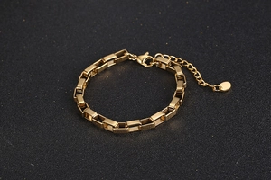 Detail of gold box chain bracelet with lobster clasp and matte rectangular links