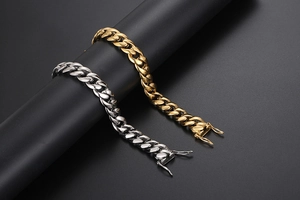 Détail de bracelets gourmette or et argent avec fermoir sécurisé sur support de présentation