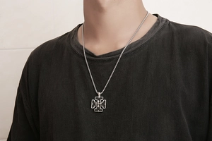 Dettaglio di una collana da uomo in acciaio al titanio con pendente a croce nera