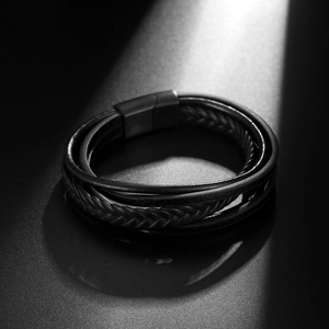 Men's multilayer braided leather bracelet with black magnetic clasp on textured dark background