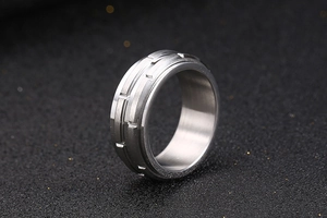 Macro shot of titanium steel ring featuring industrial brushed metal finish and grooved texture