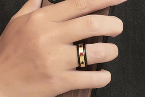 Détail d'une bague de poker hip hop montrant des motifs de cœur rouge et de pique noir