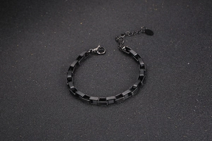 Detailed view of matte black stainless steel box chain bracelet with secure lobster clasp