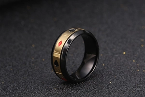 Détail de la bague en acier brossé noir avec motifs de cartes à jouer dorés pour homme