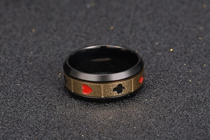 Détail macro d'une bague rotative en acier avec bords noirs et motifs de cartes de poker