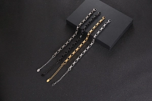 Detailed shot of four minimalist titanium steel box chain bracelets in various metallic finishes