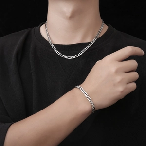Polished silver mariner chain necklace and bracelet set worn by a male model