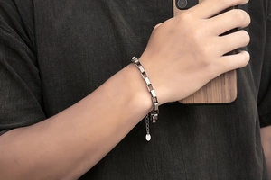 Close-up of minimalist silver stainless steel rectangular link chain bracelet on wrist
