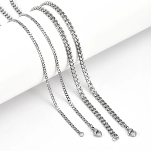 Flat Cuban chain necklaces in four widths with lobster clasps on white stands