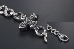 Macro shot of punk cross pattern on retro silver titanium steel bracelet with lobster clasp