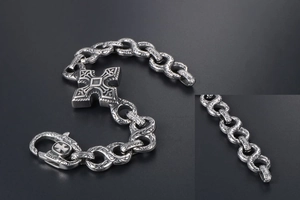 Detail of vintage gothic cross bracelet with vine engravings and large lobster clasp