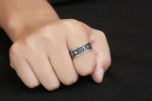 Macro view of vintage stainless steel ring with sun, moon, and stars relief patterns