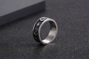 Macro view of vintage celestial sun and moon patterns on a stainless steel ring