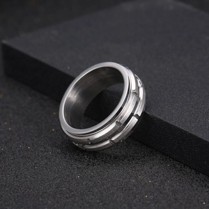 Minimalist silver titanium steel spinning ring with geometric textured gear grooves