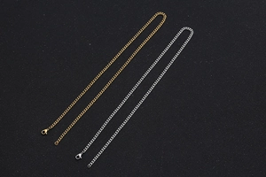 Close-up of gold and silver titanium steel curb chains with secure lobster clasps