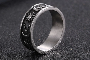 Macro detail of retro stainless steel ring with celestial sun and moon engravings