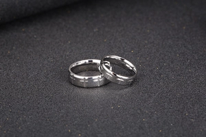 Macro shot of 316L stainless steel couple rings with engraved cross pattern
