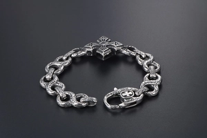 Macro shot of punk style stainless steel bracelet with cross motif and ornate carvings