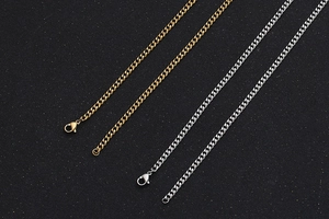 Detail of flat link Cuban chain necklaces in gold and silver with lobster clasp