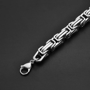 Macro detail of silver stainless steel Byzantine chain with secure lobster clasp closure