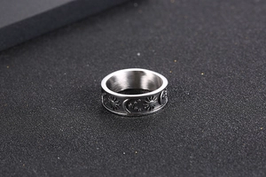 Detailed macro view of vintage stainless steel ring with embossed sun and moon patterns