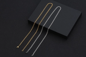 Detail of silver and gold Cuban link chains with lobster clasp on black stands