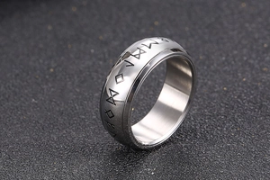 Macro shot of silver titanium ring featuring Nordic Rune engravings and polished finish
