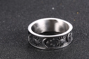Detail of vintage stainless steel ring with sun, moon, and star embossed patterns