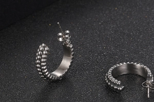 Detailed view of silver C-shaped titanium steel earrings with vintage beaded texture