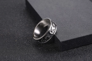 Macro detail of rotating stainless steel ring with engraved celestial sun and moon motifs