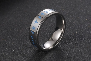 Detail of titanium steel spinning ring featuring engraved blue runic symbols on black