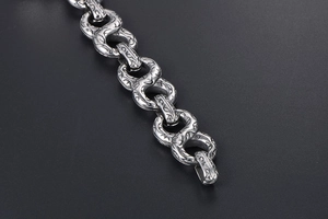 Macro detail of vintage punk chain link with intricate engraved cross patterns