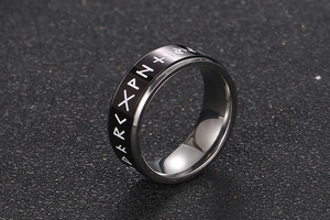 Macro detail of rotating stainless steel men's ring with engraved Nordic runes symbols