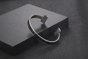 Macro shot of silver Viking rune cuff bracelet with T-shape ends and brushed metal finish