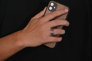 Close-up of a wide polished silver titanium steel ring for men on a hand