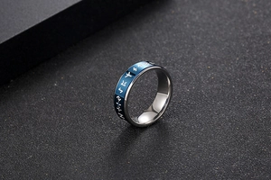 Macro shot of rotatable stainless steel ring featuring blue band with white rune symbols