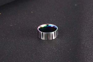 Macro detail of brushed steel ring featuring a vibrant rainbow inner plating finish