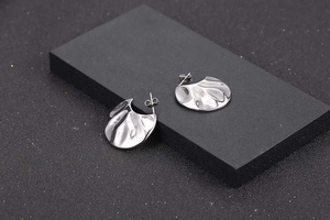 Detailed view of silver fan-shaped earrings with irregular hammered water-ripple texture