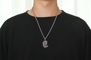 Vue détaillée du pendentif méduse argenté vintage sur une grosse chaîne à blé robuste