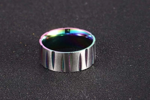 Detail of titanium steel ring with brushed silver finish and rainbow textured inner band