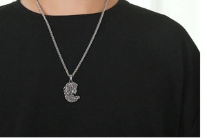 Vue détaillée du pendentif vintage Méduse en acier titane argenté sur chaîne maille